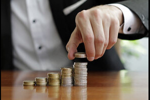 Closeup shot of a businessman's hands counting stacks of coins after business success