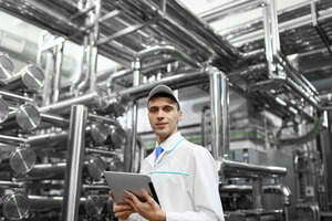 Technologist with grey tablet in his hands make a set up of the production line