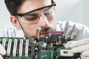 Male technician inserting chip in computer motherboard