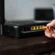 Man plugging in an ethernet cable to a wireless router