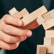 Man and wooden cubes on table. Management concept