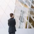 Rear view of businessman standing in front of modern corporate building