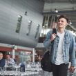 Young handsome man with a bag on his shoulder in a hurry to the airport.