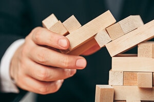 Man and wooden cubes on table. Management concept