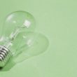 Transparent light bulb on green background