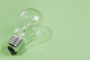 Transparent light bulb on green background