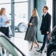 Young family choosing a car in a car showroom