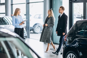 Young family choosing a car in a car showroom