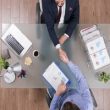 Top view of businessmen shaking hands during business negotiation in startup office