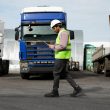 A man managing trucks by looking at his clipboard