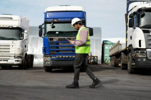 A man managing trucks by looking at his clipboard